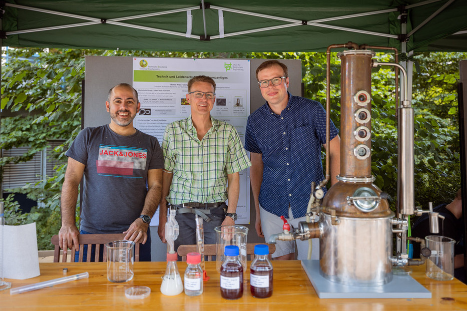 Dr. Marco Aras, Jörg Fischer und Dr. Georg Hubmann am BCI-Stand mit der Destille